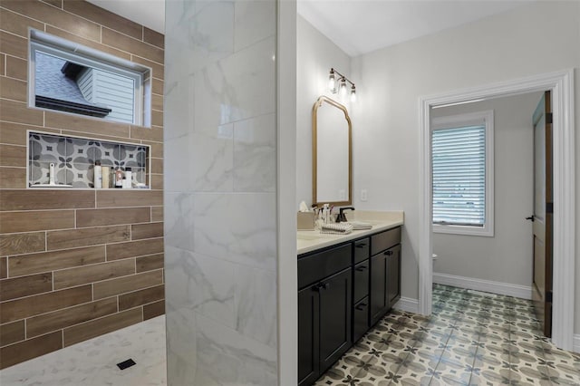 bathroom with tiled shower and vanity