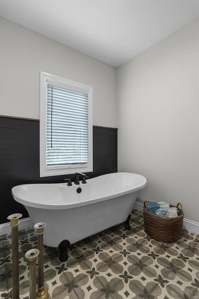 bathroom with tile patterned floors and a bath