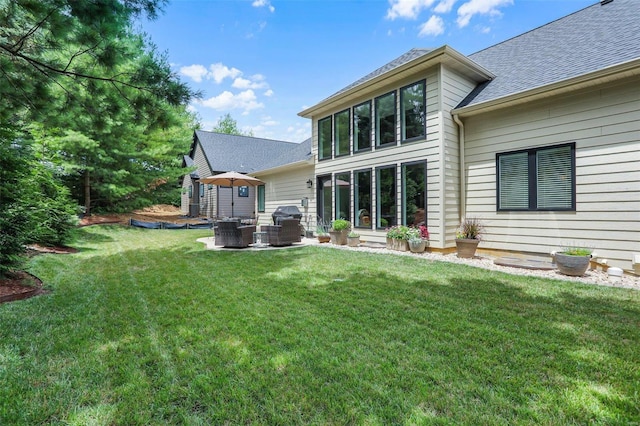 back of property with a yard and an outdoor hangout area