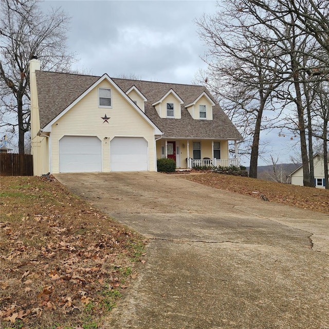 cape cod home featuring covered porch and a garage