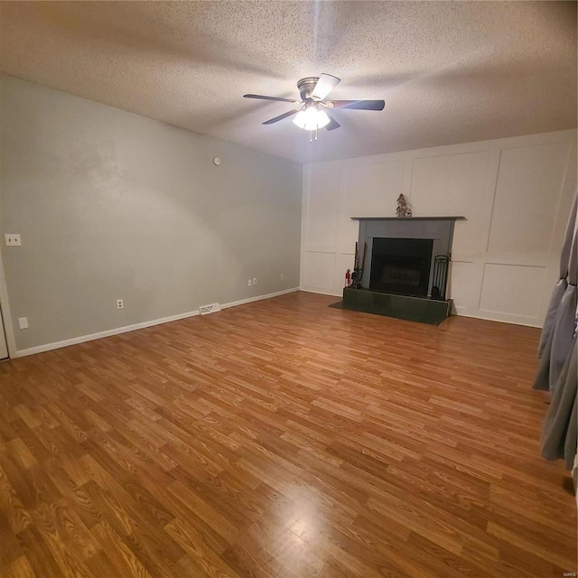 unfurnished living room featuring ceiling fan, a textured ceiling, and hardwood / wood-style flooring