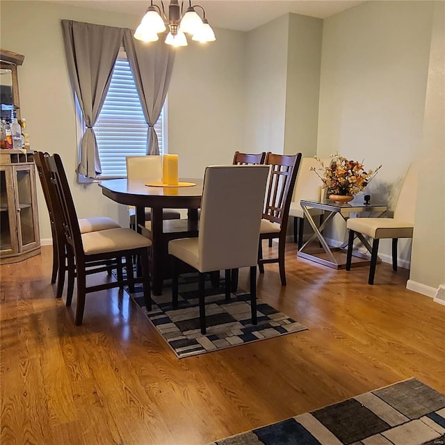 dining room with hardwood / wood-style floors and a chandelier