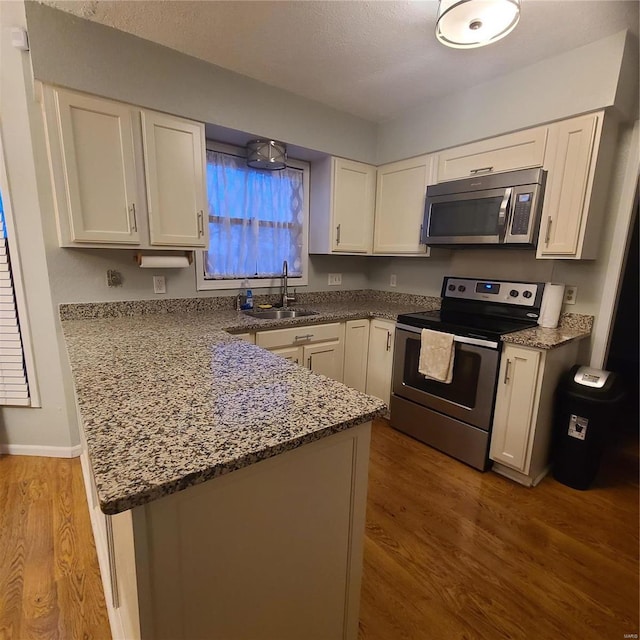 kitchen with sink, white cabinets, and appliances with stainless steel finishes