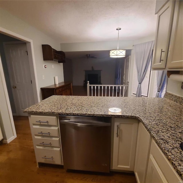 kitchen with pendant lighting, dishwasher, dark hardwood / wood-style floors, light stone counters, and kitchen peninsula