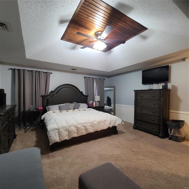 carpeted bedroom featuring ceiling fan, wood ceiling, and a textured ceiling