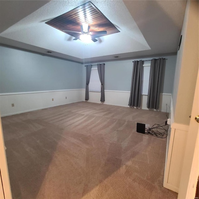 unfurnished room with carpet flooring, ceiling fan, and a textured ceiling