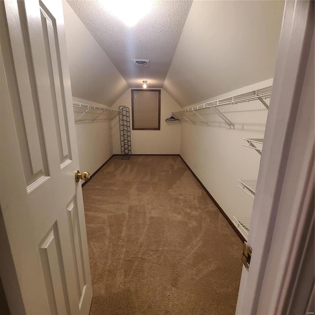 walk in closet featuring carpet floors and lofted ceiling