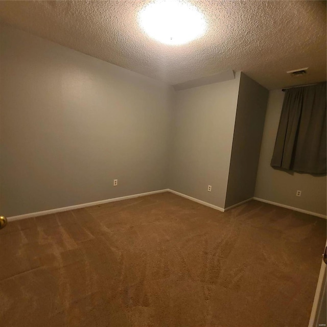 unfurnished room featuring carpet and a textured ceiling