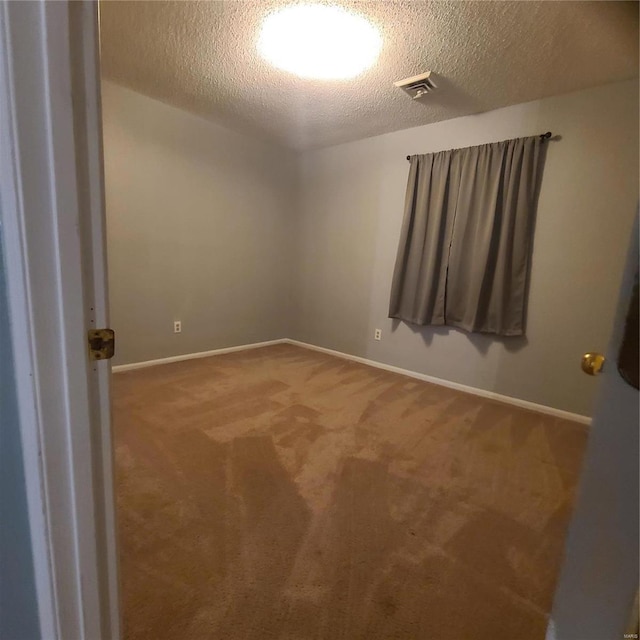 carpeted spare room featuring a textured ceiling