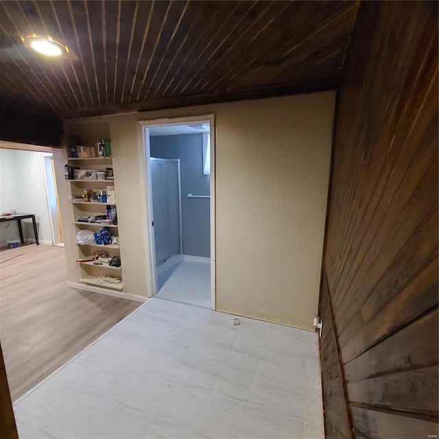 hall featuring wood walls and wood ceiling