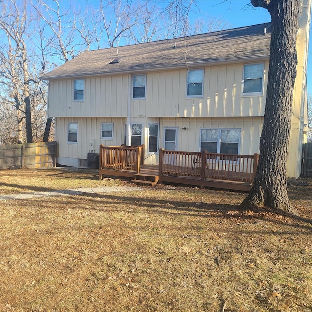 back of property with central AC unit, a deck, and a lawn