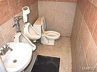 bathroom featuring toilet, tile walls, and sink