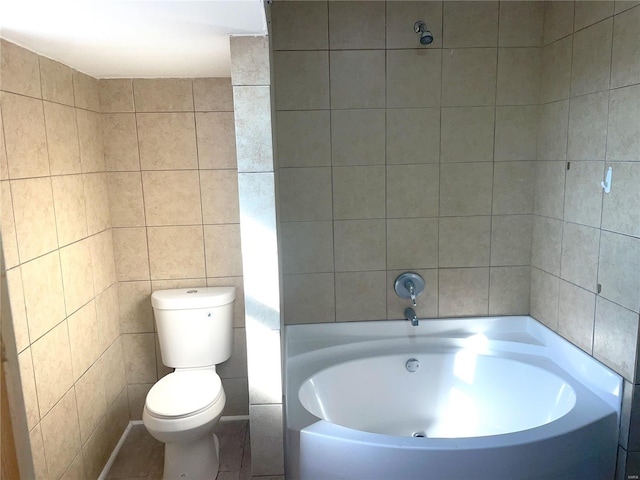 bathroom with a bathtub, tile walls, and toilet