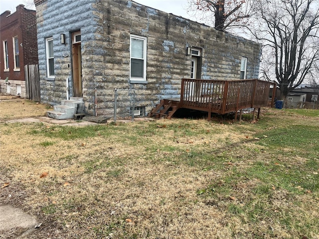 rear view of property featuring a yard and a deck