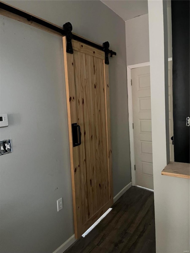 interior space featuring a barn door and dark hardwood / wood-style flooring