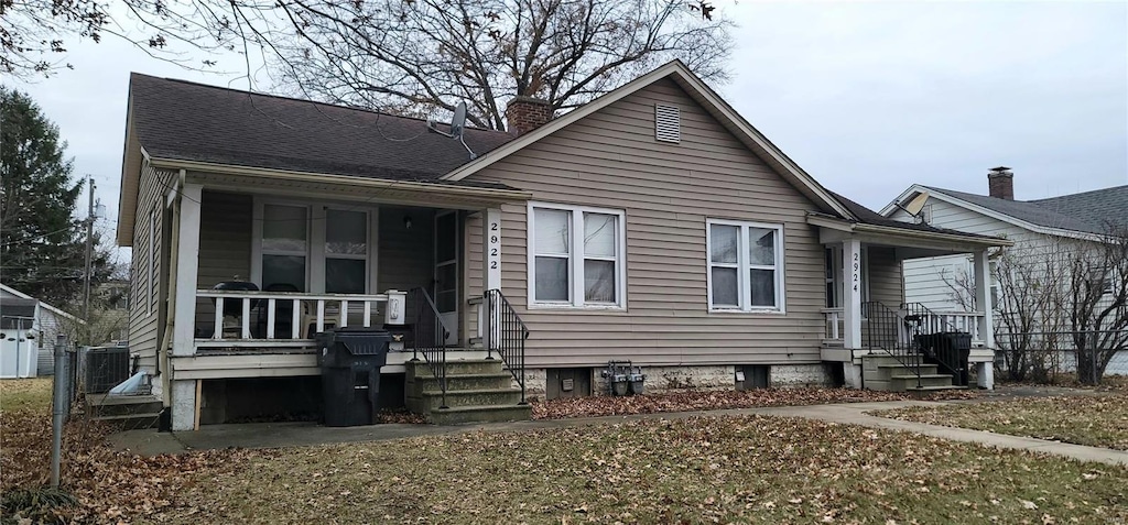 view of front of property with central AC and a front yard