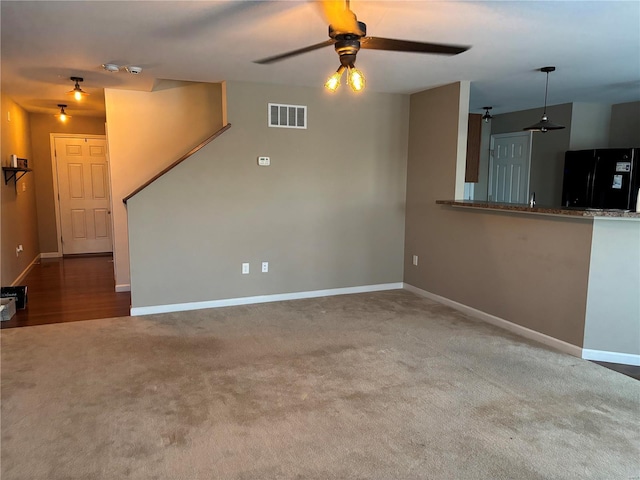 unfurnished living room with ceiling fan and carpet floors