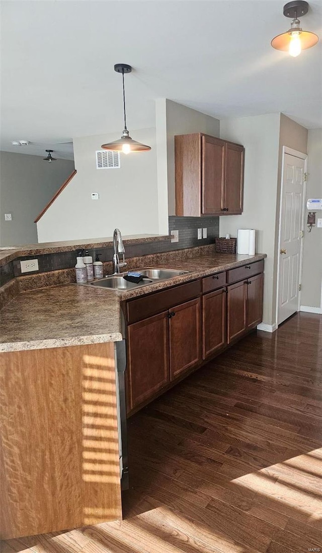 kitchen with dark wood-type flooring, sink, and pendant lighting