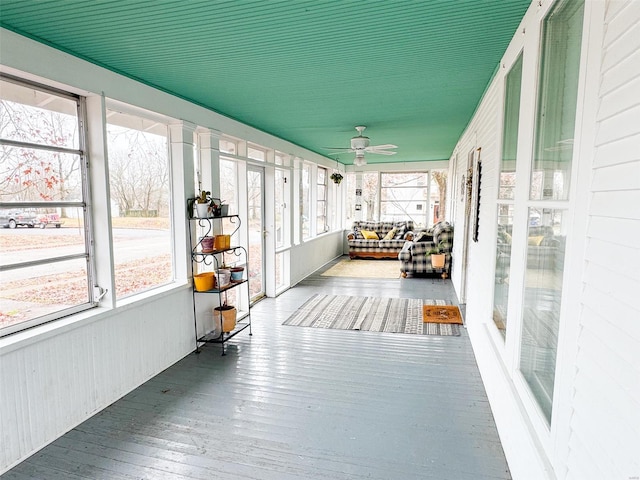 unfurnished sunroom featuring ceiling fan