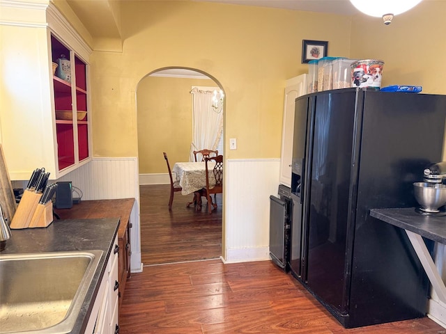 kitchen featuring white cabinetry, black refrigerator with ice dispenser, dark hardwood / wood-style floors, and sink