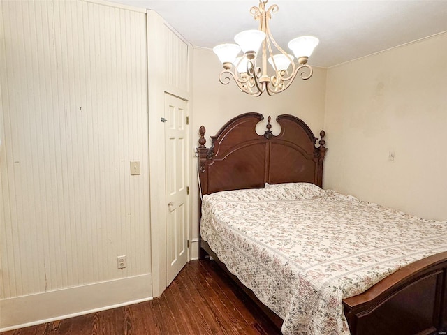 bedroom featuring dark hardwood / wood-style flooring and an inviting chandelier