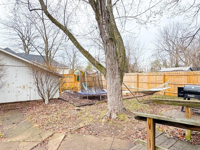 view of yard featuring a playground and a trampoline