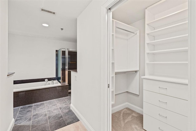 spacious closet with dark colored carpet