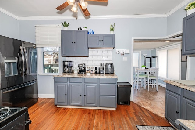 kitchen with decorative backsplash, crown molding, and fridge with ice dispenser