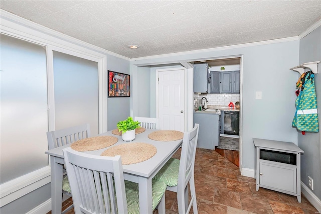 dining area featuring sink and ornamental molding