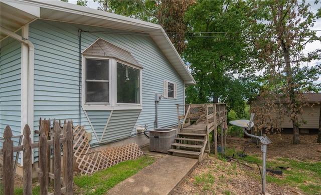 view of property exterior with central AC unit and a wooden deck