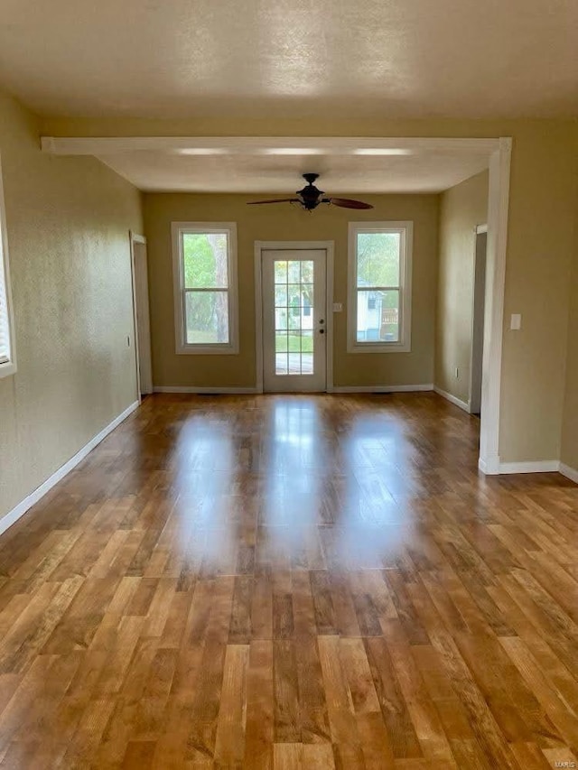 interior space featuring beam ceiling, light hardwood / wood-style flooring, and ceiling fan