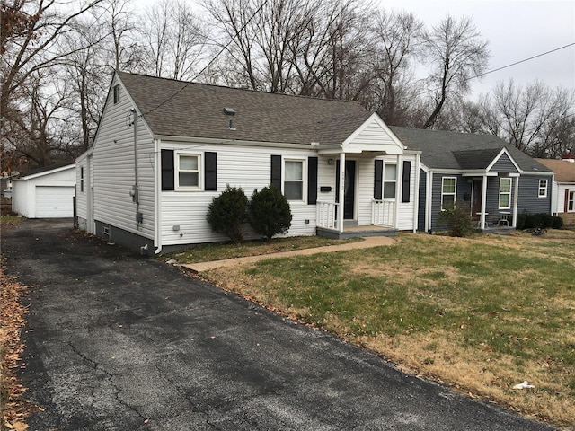 view of front of home with a front lawn, an outdoor structure, and a garage