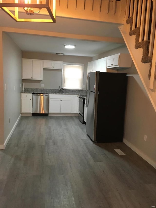 kitchen featuring white cabinets, appliances with stainless steel finishes, dark hardwood / wood-style flooring, and sink