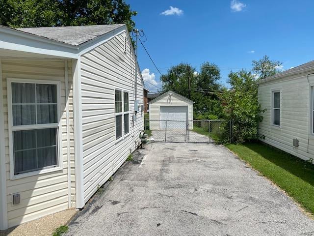 view of home's exterior with a garage and an outbuilding