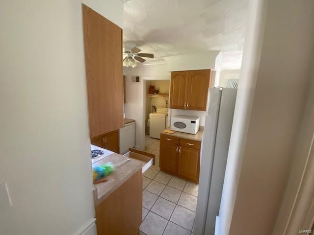 kitchen featuring ceiling fan, white appliances, and light tile patterned floors