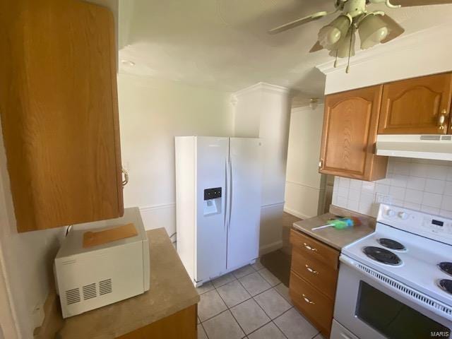 kitchen featuring decorative backsplash, light tile patterned flooring, white appliances, and ceiling fan