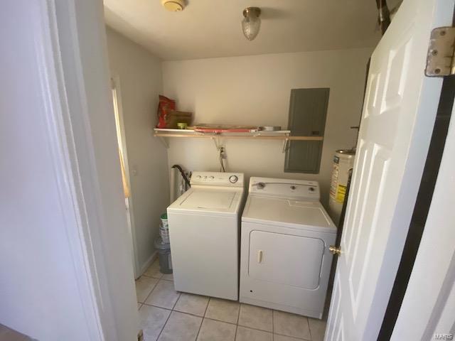 washroom with washer and dryer, light tile patterned floors, and water heater