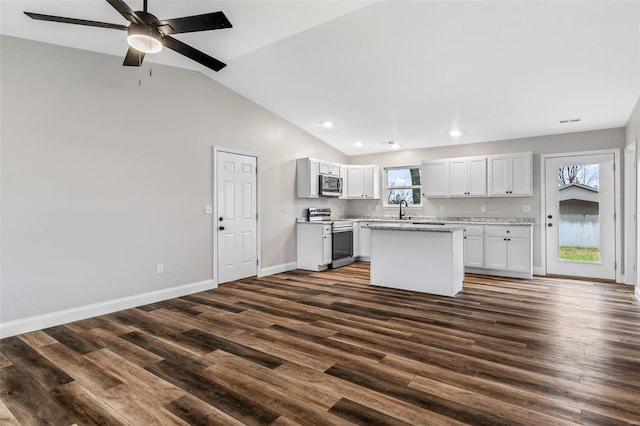 kitchen featuring appliances with stainless steel finishes, vaulted ceiling, ceiling fan, a center island, and white cabinetry