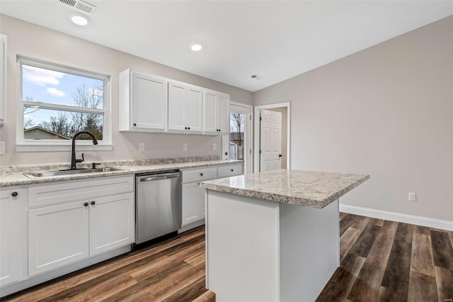 kitchen featuring stainless steel dishwasher, a kitchen island, white cabinetry, and sink