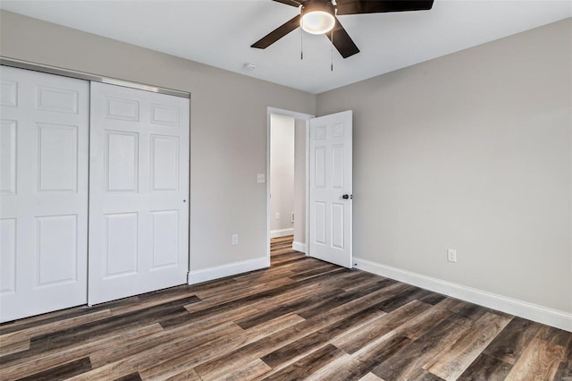 unfurnished bedroom with ceiling fan, a closet, and dark wood-type flooring