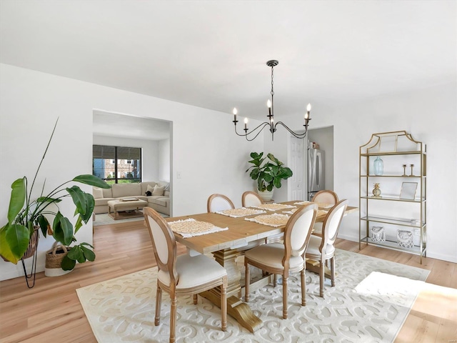 dining area featuring an inviting chandelier and light hardwood / wood-style flooring