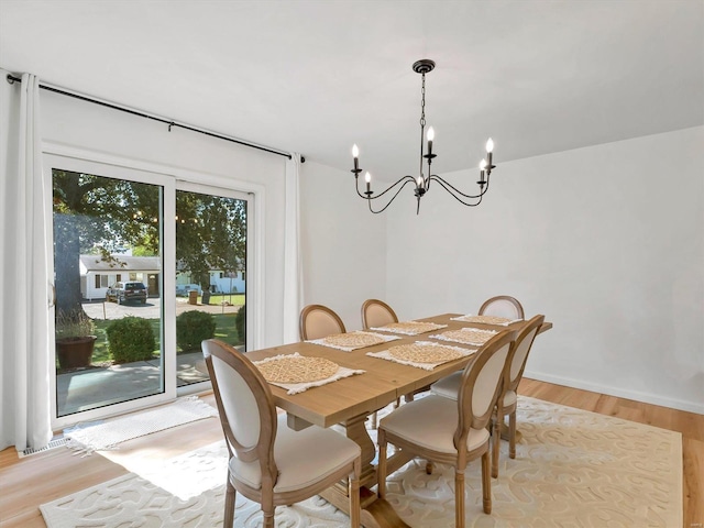 dining space featuring light hardwood / wood-style floors and a notable chandelier