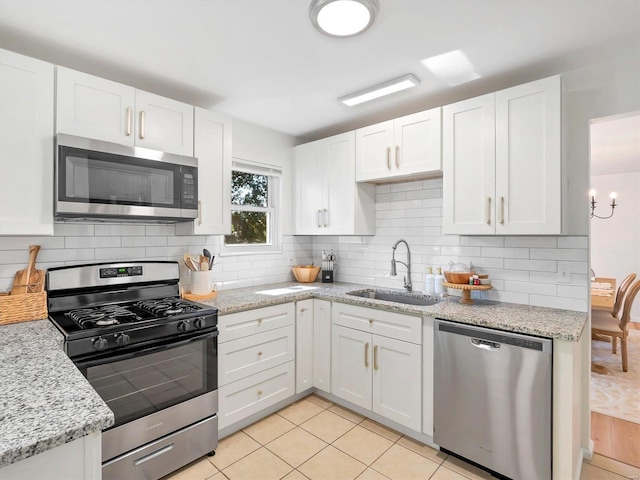 kitchen with white cabinets, stainless steel appliances, light tile patterned flooring, and sink