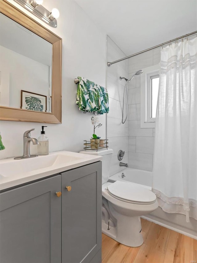 full bathroom featuring hardwood / wood-style floors, vanity, toilet, and shower / tub combo with curtain