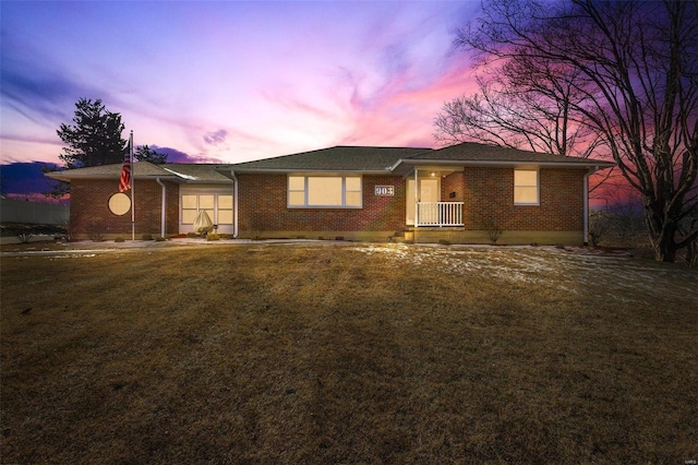 single story home with a yard and covered porch