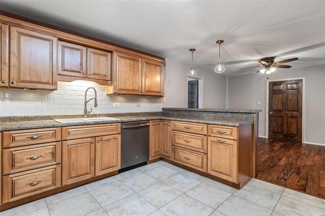 kitchen featuring sink, hanging light fixtures, decorative backsplash, stainless steel dishwasher, and kitchen peninsula