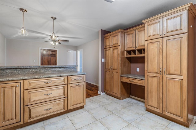 kitchen with pendant lighting, light tile patterned floors, built in desk, and ceiling fan