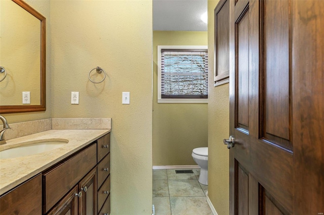 bathroom featuring vanity, tile patterned floors, and toilet