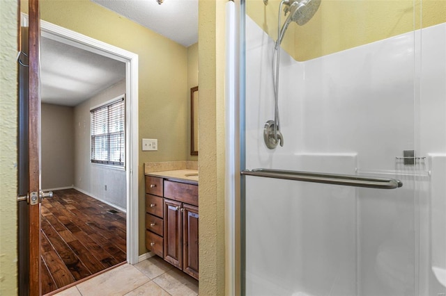 bathroom featuring vanity, an enclosed shower, and tile patterned flooring