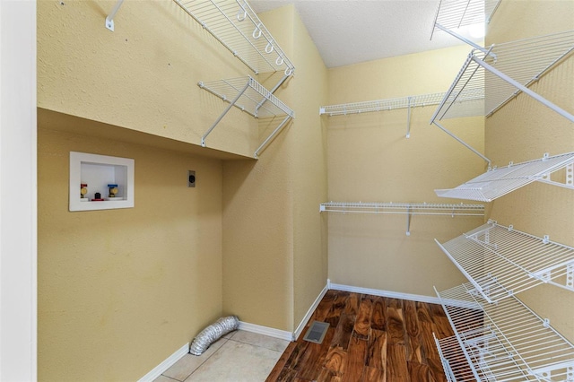 clothes washing area featuring hardwood / wood-style floors, electric dryer hookup, and washer hookup